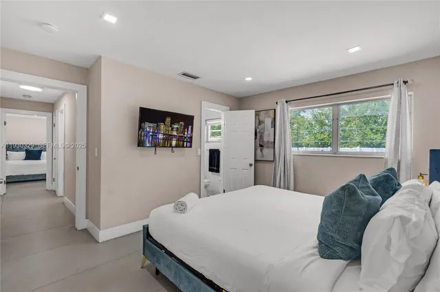 a bedroom with a large bed and a large window