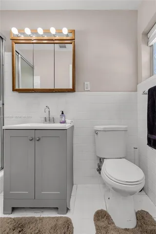 a bathroom with a toilet a sink and mirror
