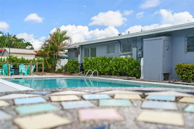 a view of a house with swimming pool and sitting area