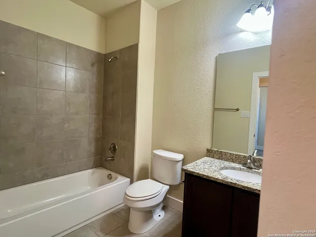 a bathroom with a granite countertop toilet a sink and bathtub