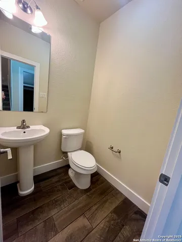 a bathroom with a toilet sink and mirror