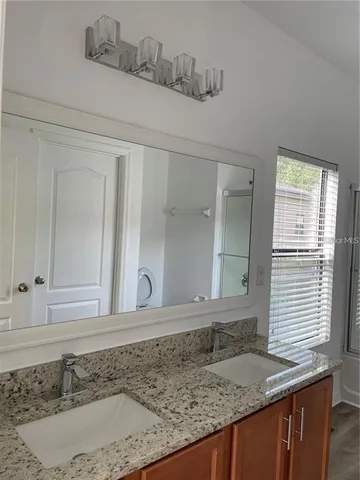 a bathroom with a granite countertop sink and a mirror
