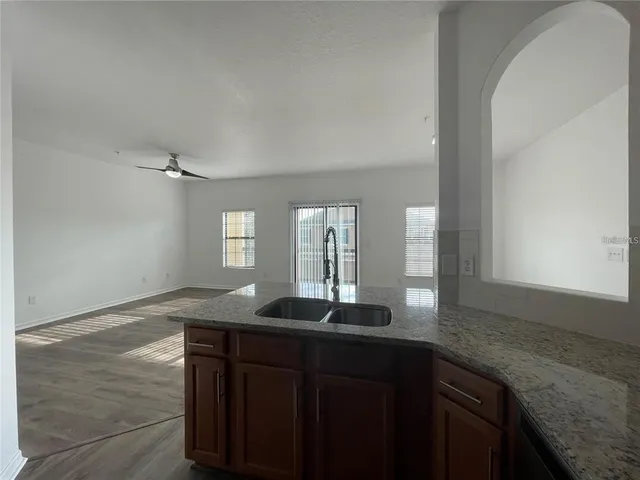 a kitchen with granite countertop cabinets sink and window