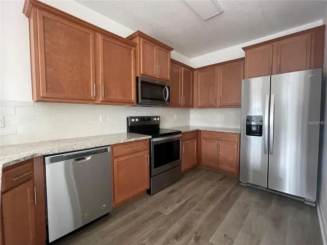 a kitchen with a sink a refrigerator and cabinets