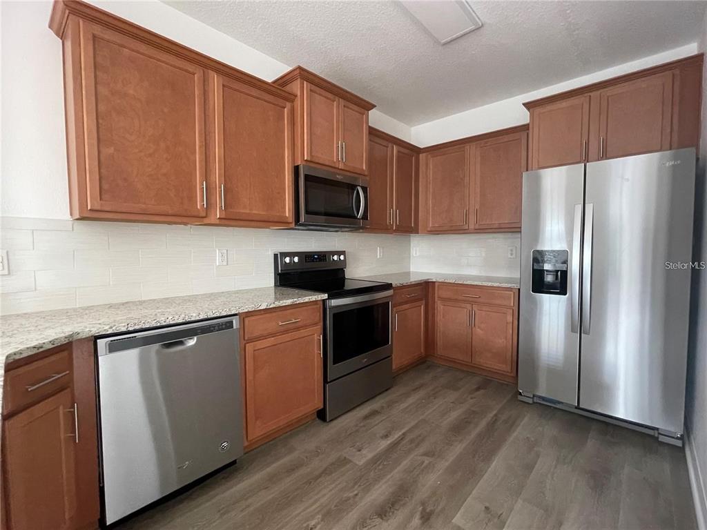 3408 Seneca Club Loop, Unit A Orlando, FL 32808 - Photo 10 of 36 a kitchen with a sink a refrigerator and cabinets