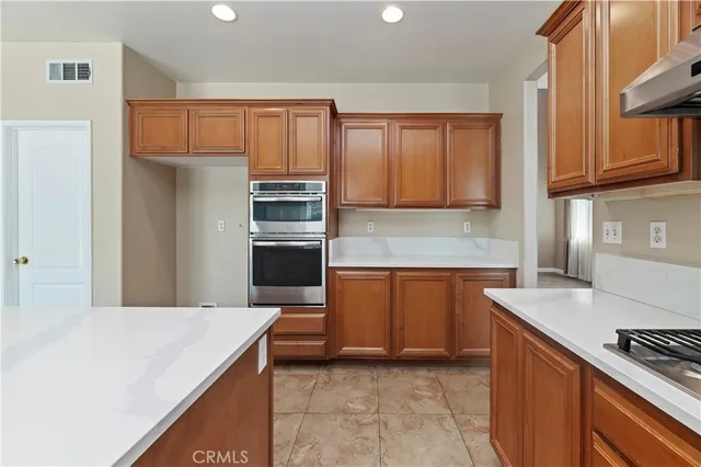 a kitchen with stainless steel appliances granite countertop a refrigerator and a stove top oven