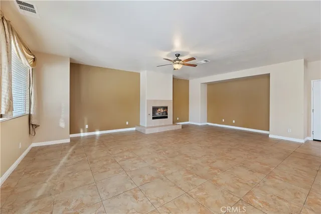 a view of an empty room with a ceiling fan