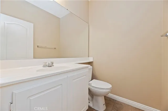 a bathroom with a granite countertop toilet and a sink