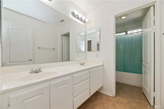 a bathroom with a double vanity sink and mirror