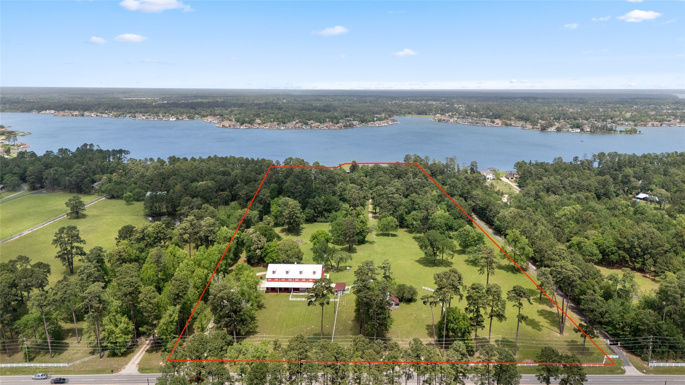 15126 Walden Road Montgomery, TX 77356 - Photo 1 of 50 Expansive property with a barndominium, surrounded by lush greenery and trees, offering privacy and tranquility. The property overlooks unobstructed views of Lake Conroe, providing beautiful water views and a serene atmosphere. (Red outline approximate)