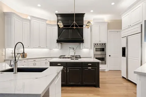 a kitchen with stainless steel appliances kitchen island a sink stove and refrigerator