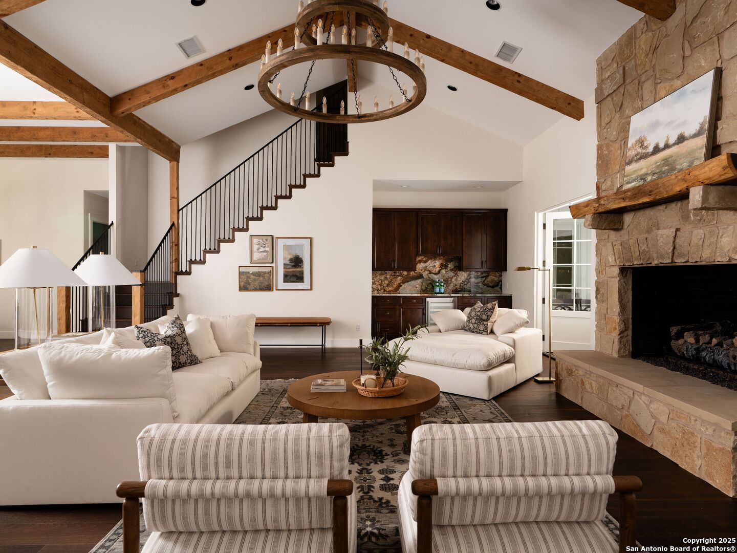 862 Grape Creek Road Fredericksburg, TX 78624 - Photo 17 of 90 a living room with furniture a fireplace and a chandelier