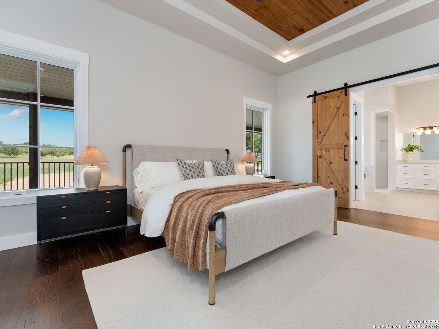 862 Grape Creek Road Fredericksburg, TX 78624 - Photo 31 of 90 a spacious bedroom with a bed and wooden floor