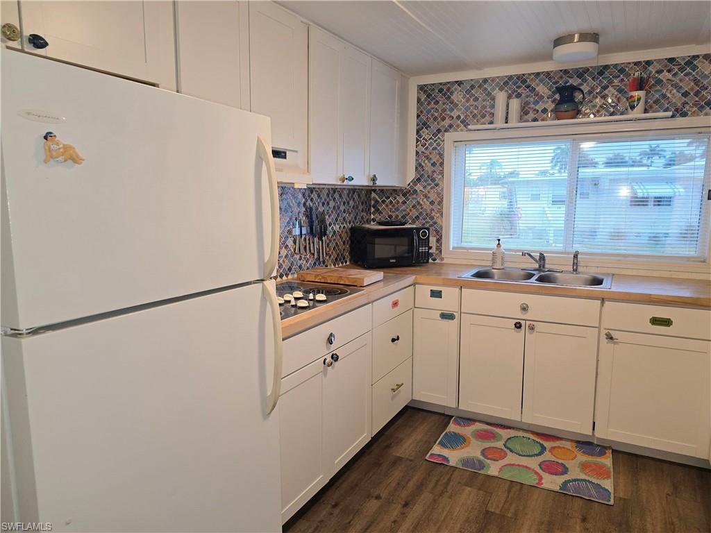 21 Diamond Lane, Unit D21 Naples, FL 34112 - Photo 2 of 5 a kitchen with white cabinets and white appliances