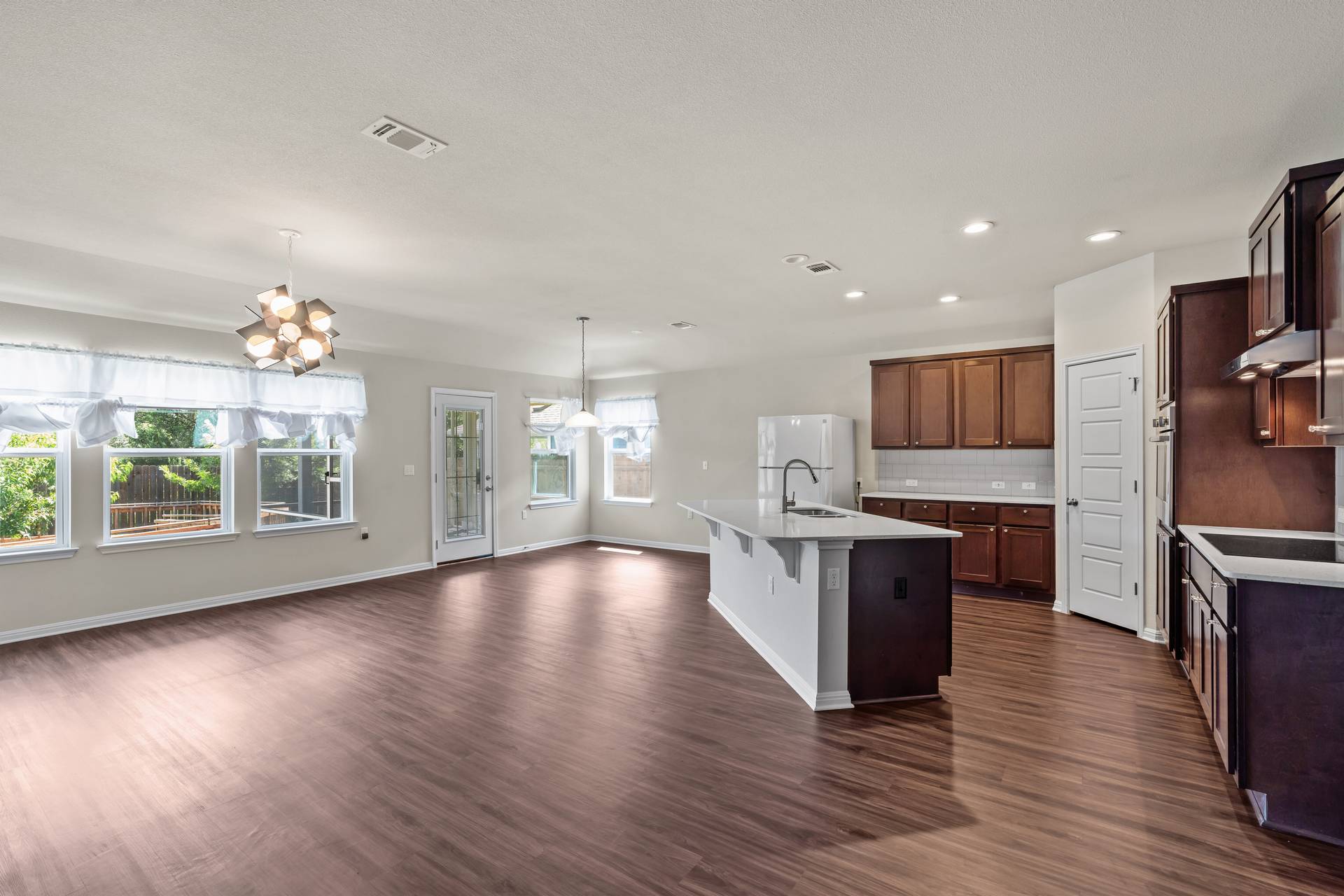 16512 Enamorado Road Manor, TX 78653 - Photo 5 of 31 An open-concept living area flows into a functional kitchen with an island, perfect for entertaining.