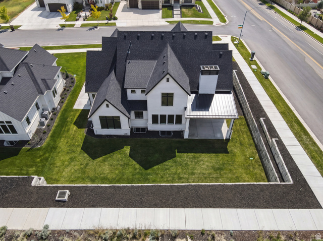 1682 North 1950 W Street, Unit 9 Provo, UT 84604 - Photo 70 of 84 Contemporary white exterior with dark-framed windows, a covered patio, a prominent chimney feature, and a newly laid asphalt roof