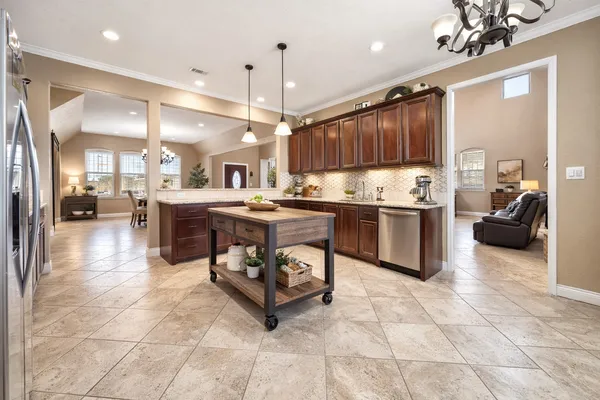 a large kitchen with kitchen island granite countertop a large counter top and stainless steel appliances
