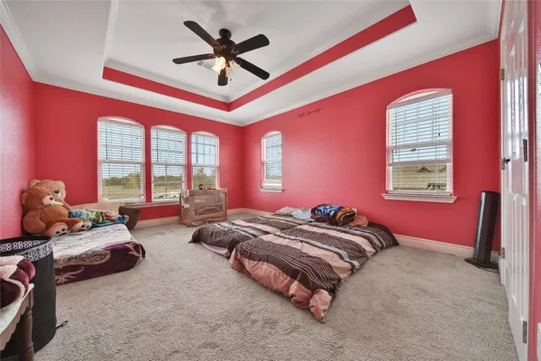 a view of a livingroom with a ceiling fan and windows