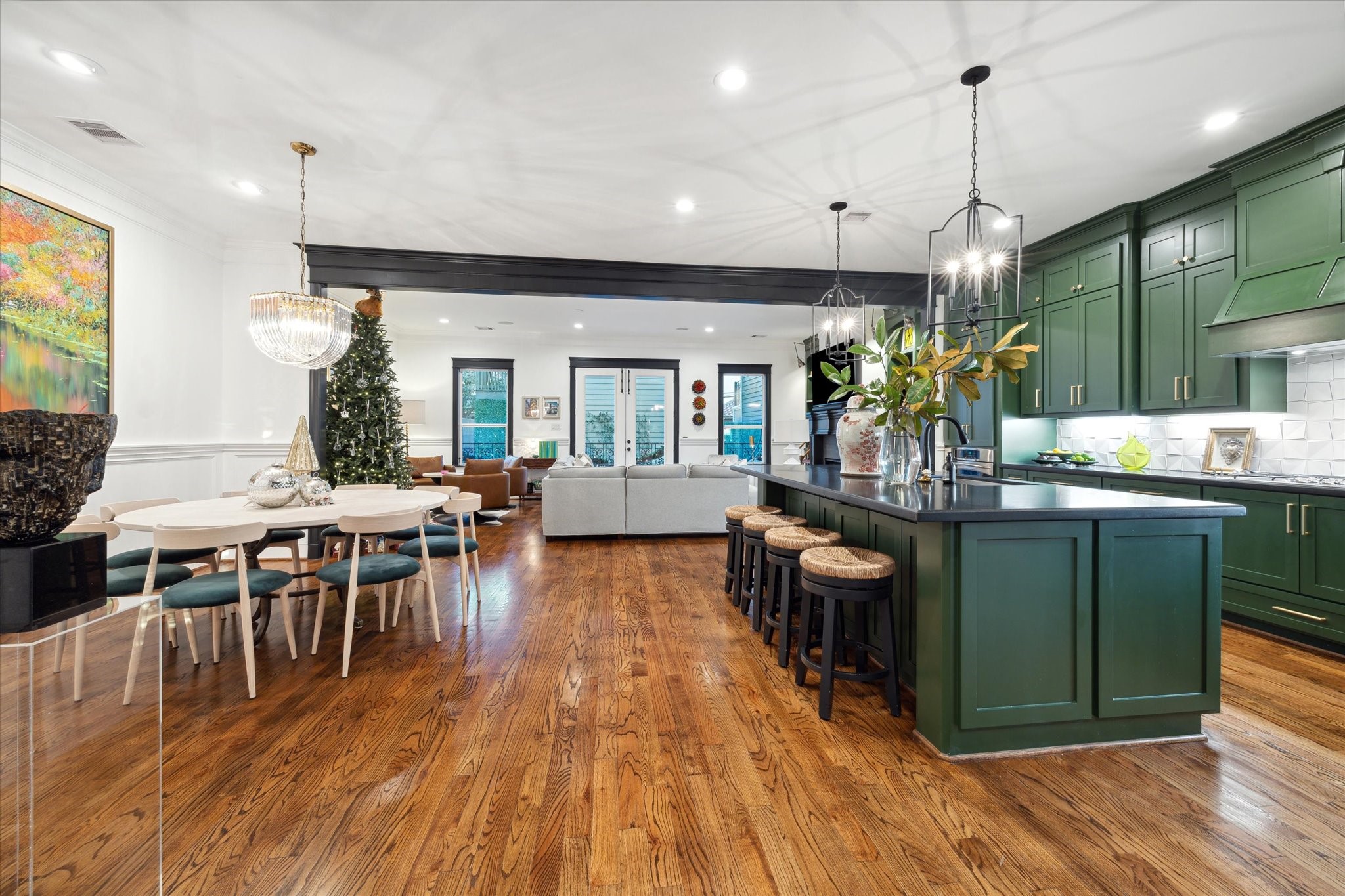 606 Rutland Street Houston, TX 77007 - Photo 16 of 48 This spacious open-concept kitchen and living area features rich wooden floors, elegant green cabinetry, pendant lights over the large island with bar seating. The dining area is highlighted by a modern chandelier.