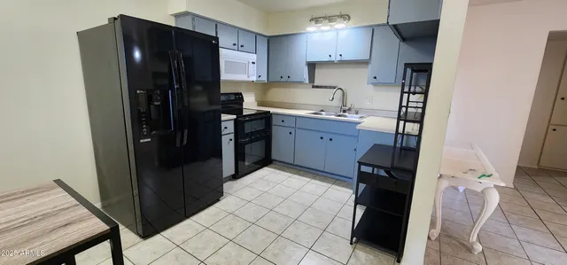 a kitchen with a refrigerator and a stove top oven