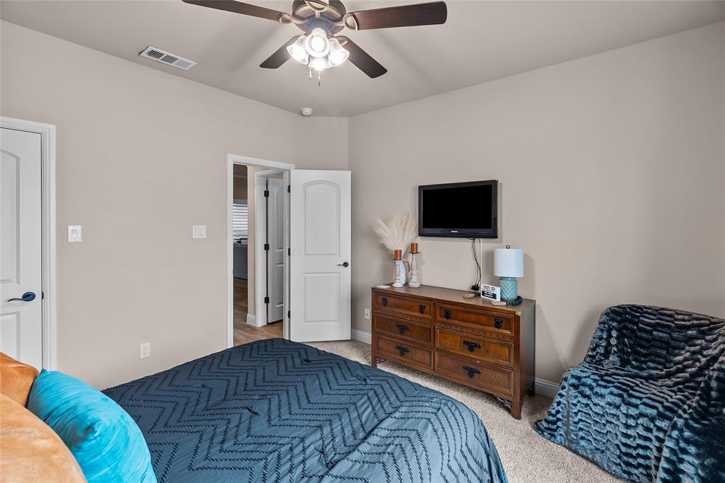 222 Rees Avenue Godley, TX 76044 - Photo 18 of 25 a bedroom with a bed and a flat tv screen on a dresser