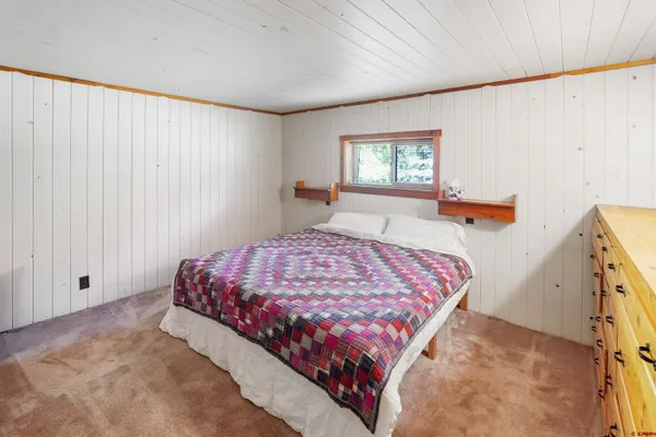 a bed sitting in a bedroom next to a window