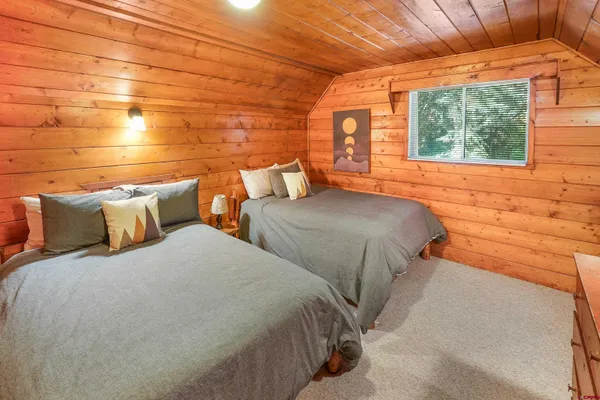 a bedroom with two beds and a potted plant