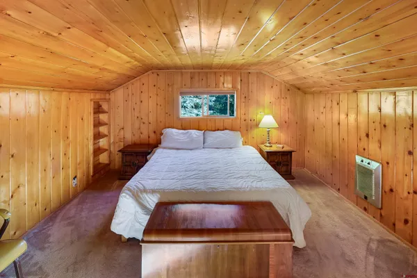 a bed sitting in a spacious bedroom next to a window