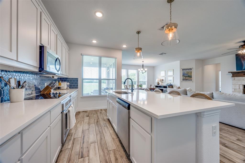 1933 Franklin Road Tom Bean, TX 75090 - Photo 13 of 28 a kitchen with stainless steel appliances granite countertop a sink dishwasher and white cabinets with wooden floor