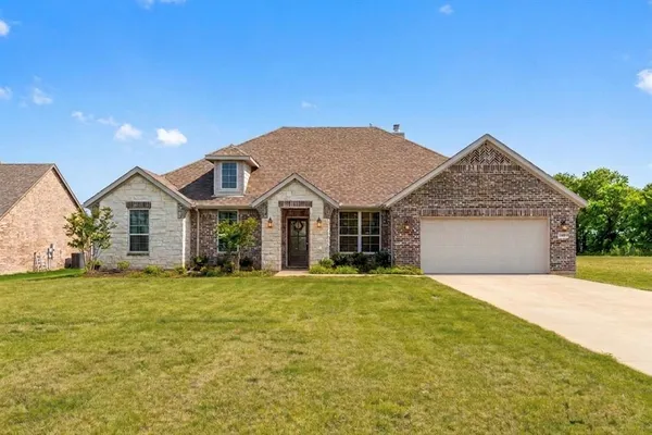 a front view of a house with a yard and garage