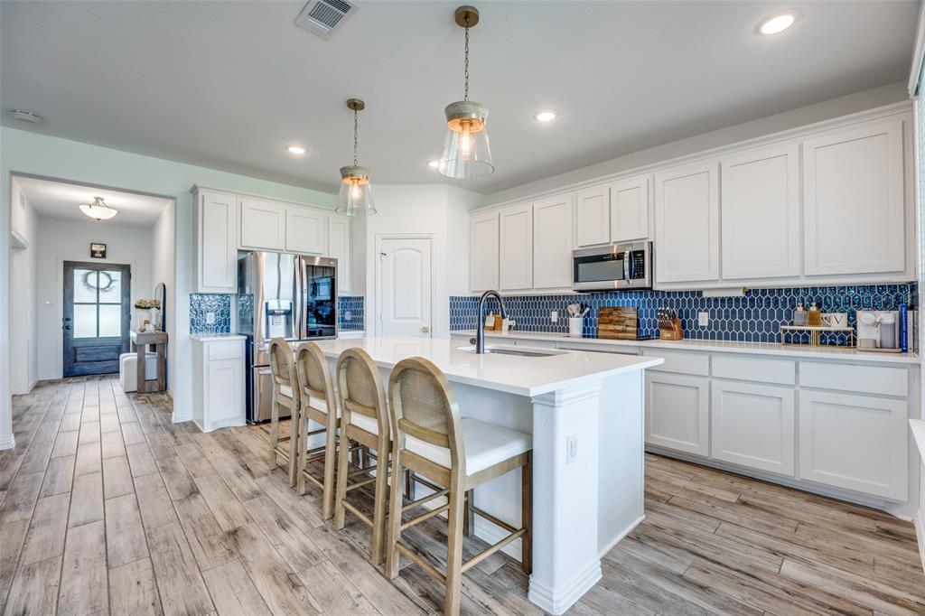 1933 Franklin Road Tom Bean, TX 75090 - Photo 7 of 28 a kitchen with stainless steel appliances granite countertop a refrigerator a stove top oven a sink dishwasher and white cabinets with wooden floor