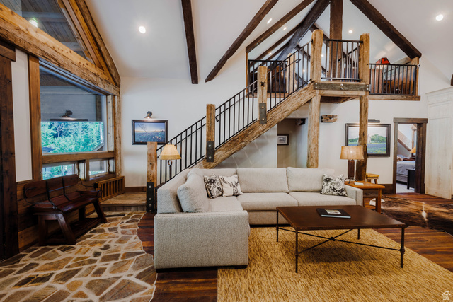 1667 West Tollgate Cyn Road Coalville, UT 84017 - Photo 35 of 61 Vaulted ceiling with exposed wood beams, a prominent staircase with iron railings, flagstone flooring, and large windows