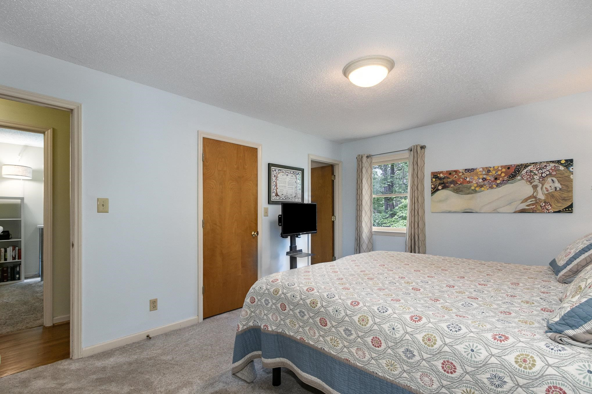 3200 Twin Streams Road Chapel Hill, NC 27516 - Photo 20 of 46 a bedroom with a large bed and a flat screen tv