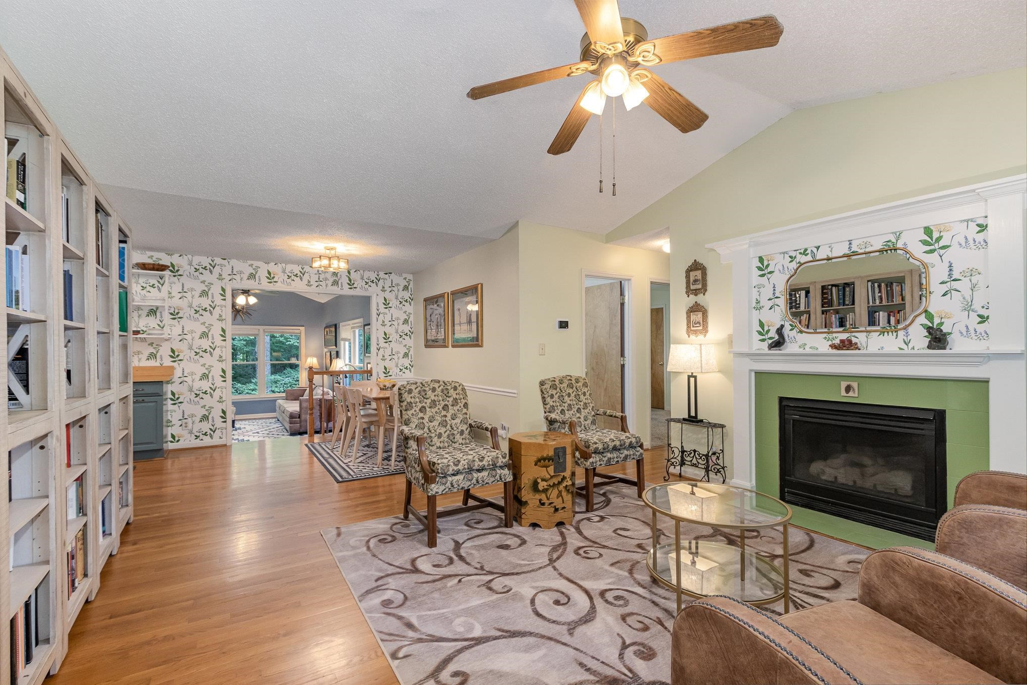 3200 Twin Streams Road Chapel Hill, NC 27516 - Photo 7 of 46 a living room with furniture a fireplace and a chandelier
