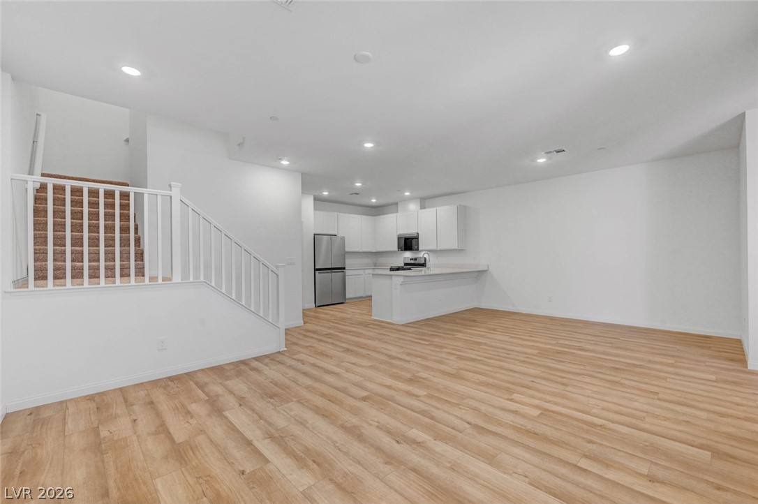 3548 Dimora Street Henderson, NV 89044 - Photo 11 of 40 Unfurnished living room featuring recessed lighting, light wood-style floors, stairway, and baseboards