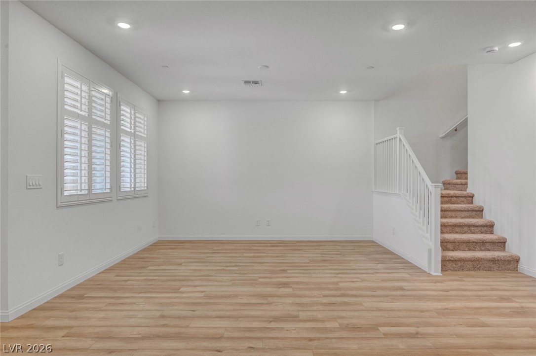 3548 Dimora Street Henderson, NV 89044 - Photo 13 of 40 Unfurnished living room with recessed lighting, stairway, visible vents, light wood-style floors, and baseboards