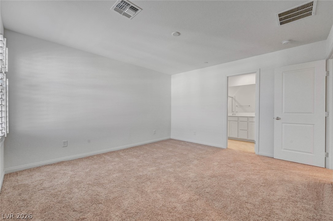3548 Dimora Street Henderson, NV 89044 - Photo 31 of 40 Empty room featuring baseboards, visible vents, lofted ceiling, and light colored carpet