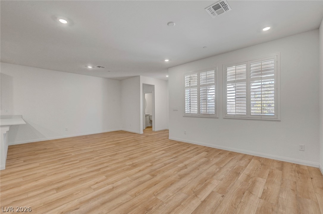 3548 Dimora Street Henderson, NV 89044 - Photo 10 of 40 Unfurnished living room with light wood finished floors, baseboards, visible vents, and recessed lighting