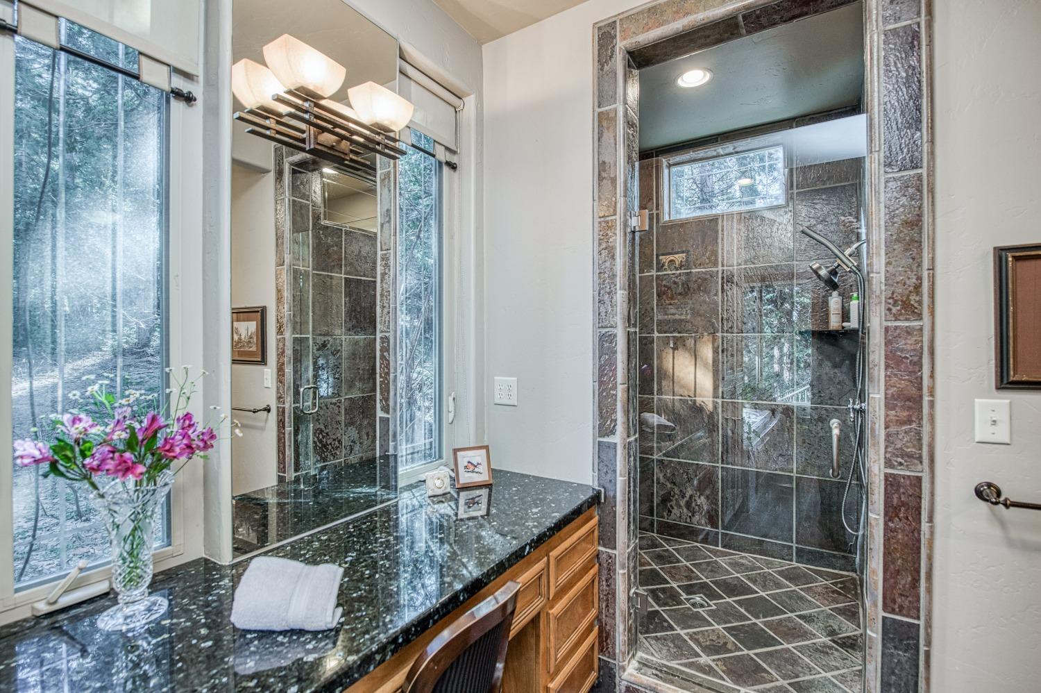 42676 Granite Circle Shaver Lake, CA 93664 - Photo 28 of 99 a bathroom with a granite countertop shower a mirror and a sink