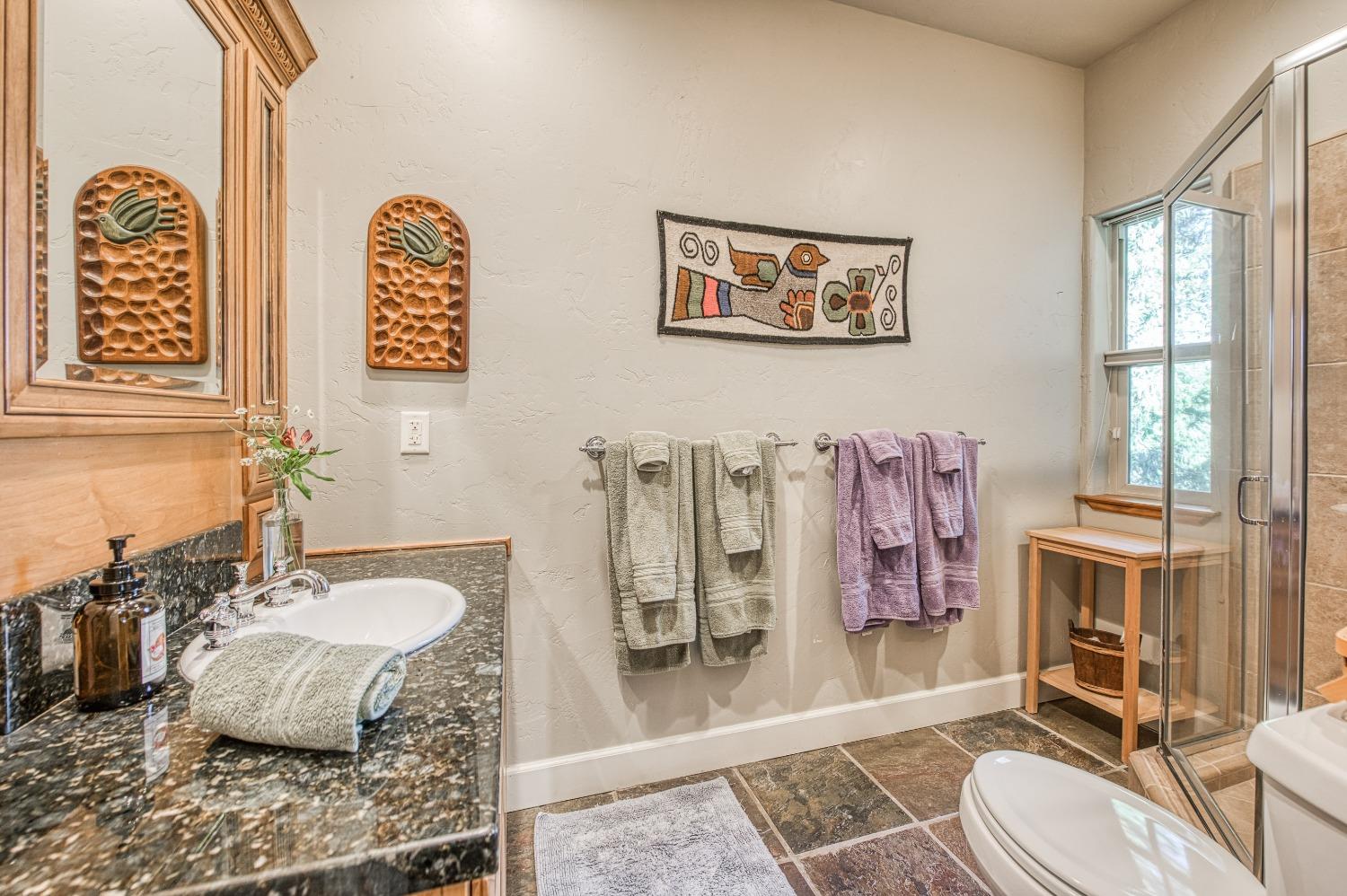 42676 Granite Circle Shaver Lake, CA 93664 - Photo 42 of 99 a bathroom with a granite countertop sink and a mirror