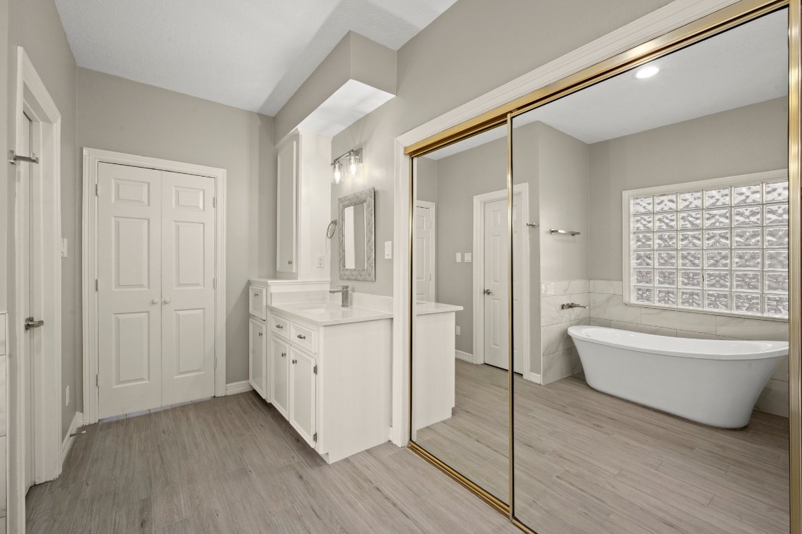 8222 Redchurch Drive Spring, TX 77379 - Photo 13 of 36 a bathroom with a double vanity sink a mirror and a bathtub