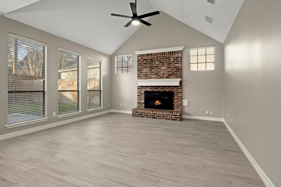 8222 Redchurch Drive Spring, TX 77379 - Photo 14 of 36 wooden floor fireplace and windows in an empty room