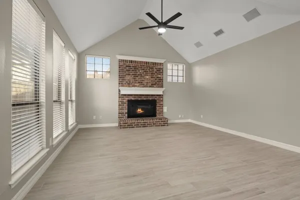 a view of an empty room with a fireplace and a window