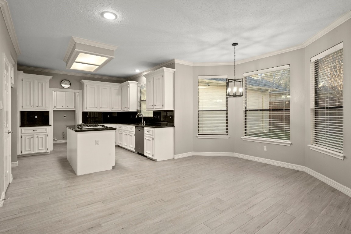8222 Redchurch Drive Spring, TX 77379 - Photo 18 of 36 a large kitchen with granite countertop a stove a sink a refrigerator and white cabinets with wooden floor