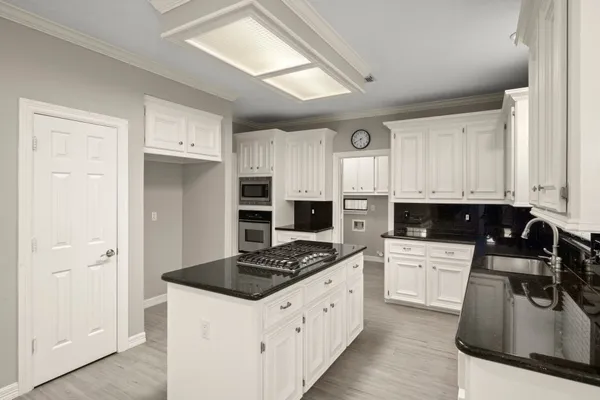a kitchen with granite countertop a sink stove and refrigerator