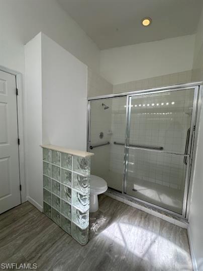 12691 Eagle Pointe Circle Fort Myers, FL 33913 - Photo 12 of 22 Bathroom featuring toilet, wood finished floors, and a stall shower