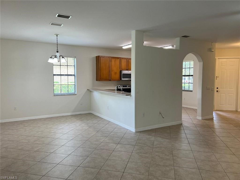 7515 Bristol Circle Naples, FL 34120 - Photo 14 of 42 a view of an empty room with window and wooden floor