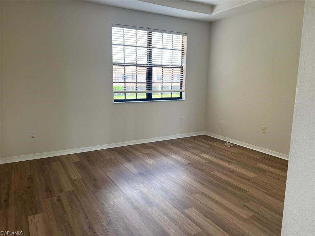 7515 Bristol Circle Naples, FL 34120 - Photo 29 of 42 an empty room with wooden floor and windows