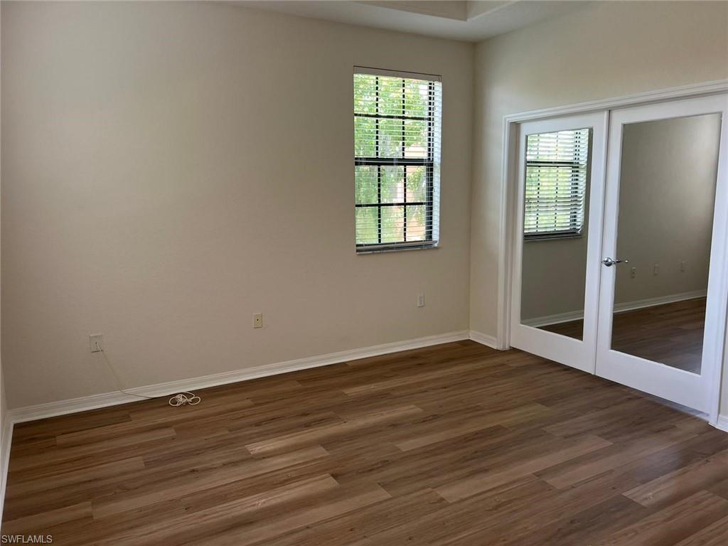 7515 Bristol Circle Naples, FL 34120 - Photo 31 of 42 an empty room with wooden floor and windows