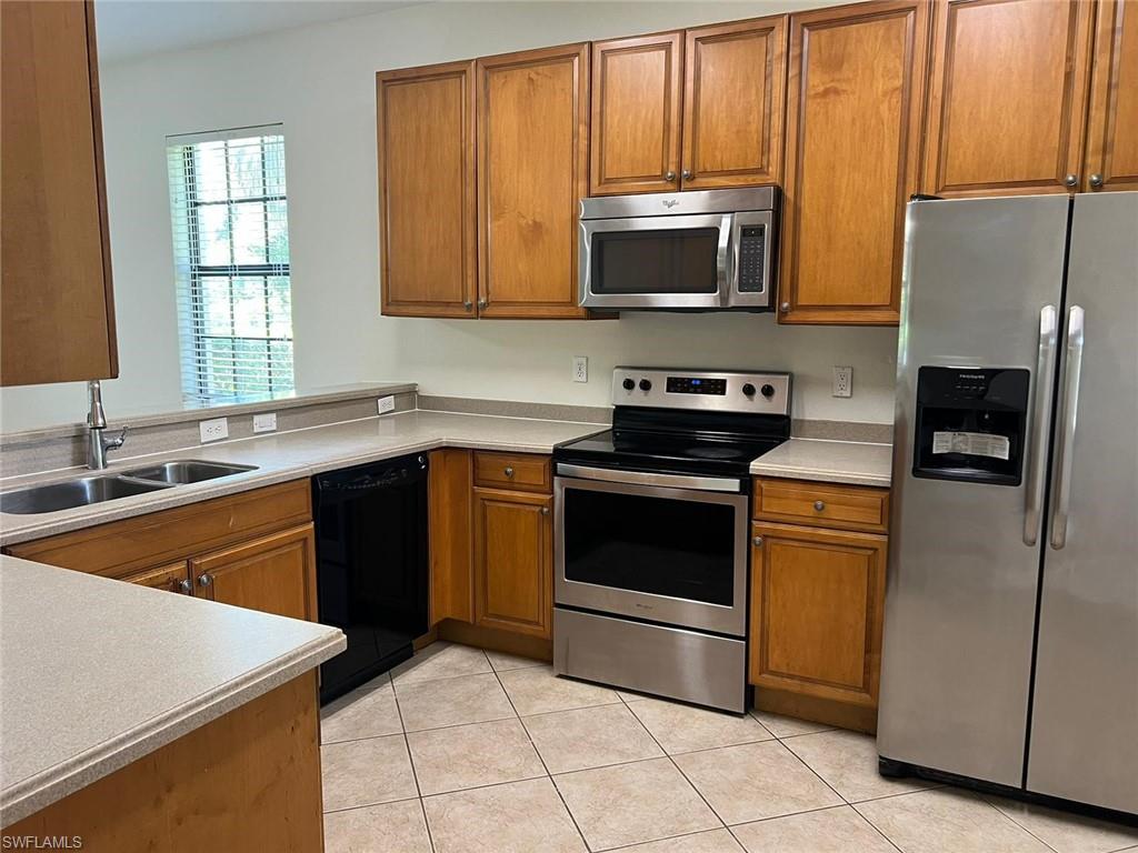 7515 Bristol Circle Naples, FL 34120 - Photo 10 of 42 a kitchen with stainless steel appliances granite countertop a stove microwave and sink